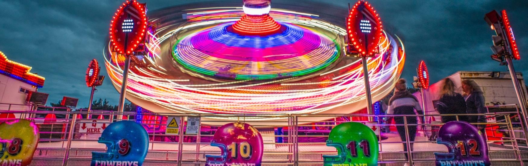 Neon lights illuminate the spinning ride at the funfair in Bournemouth