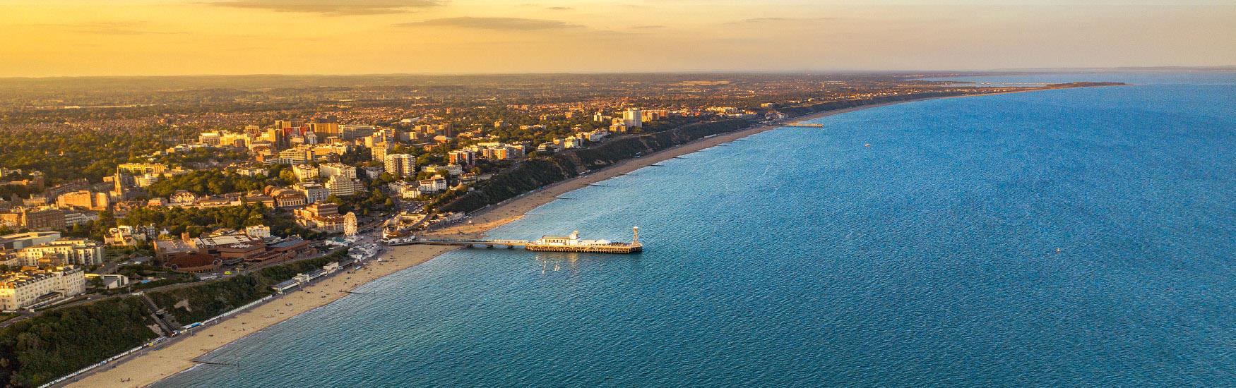 Golden hazy aerial photograph of Bournemouth Pier from above.