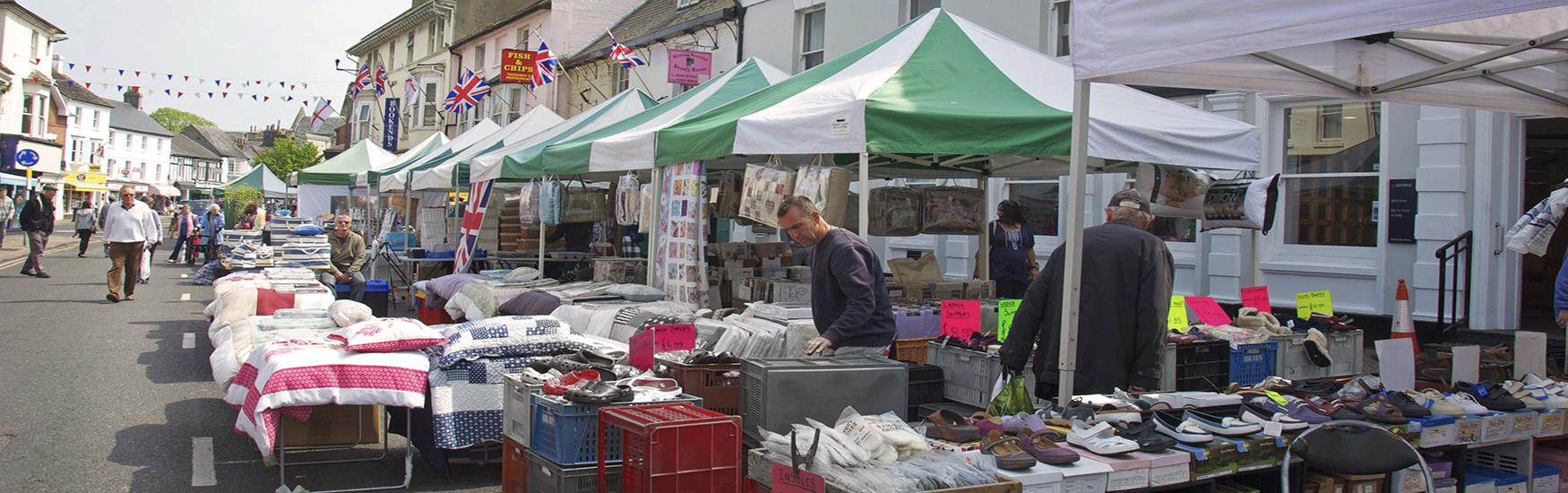 Market stalls lined up along Christchurch high street as customers browse the goods on sale