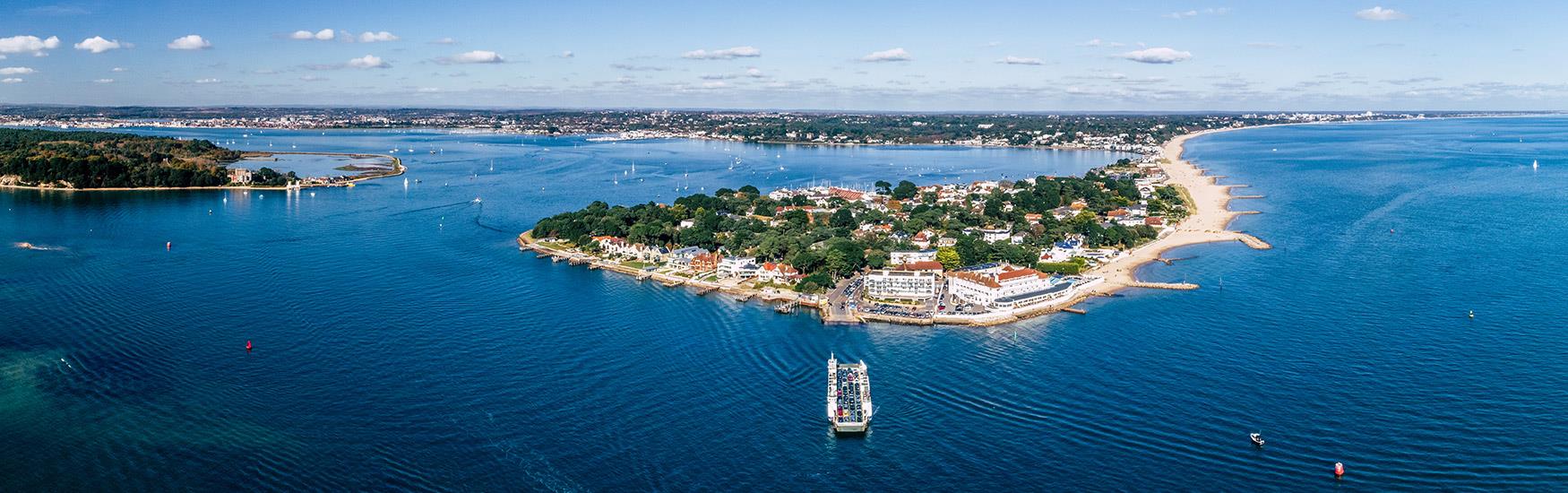 Aerial shot of Sandbanks in Poole on a beautiful sunny day with the ferry arriving to dock