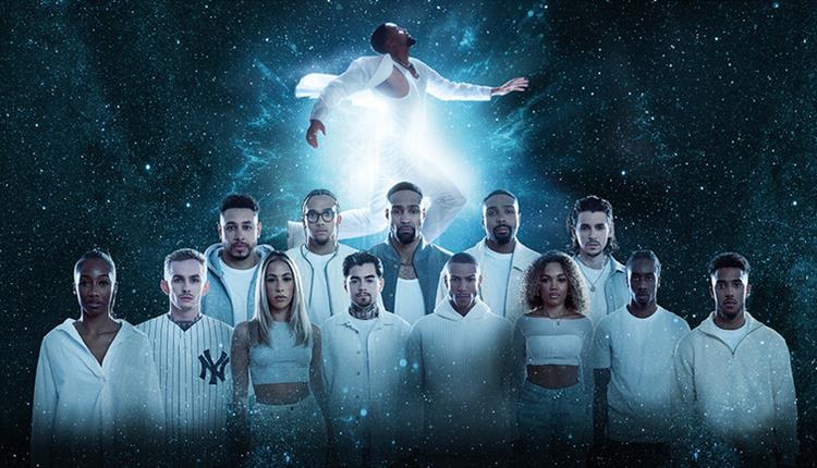 The diversity dance team all wearing white with a space-like background