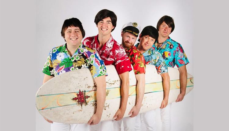 5 guys holding a surfboard in Hawaiian t-shirts