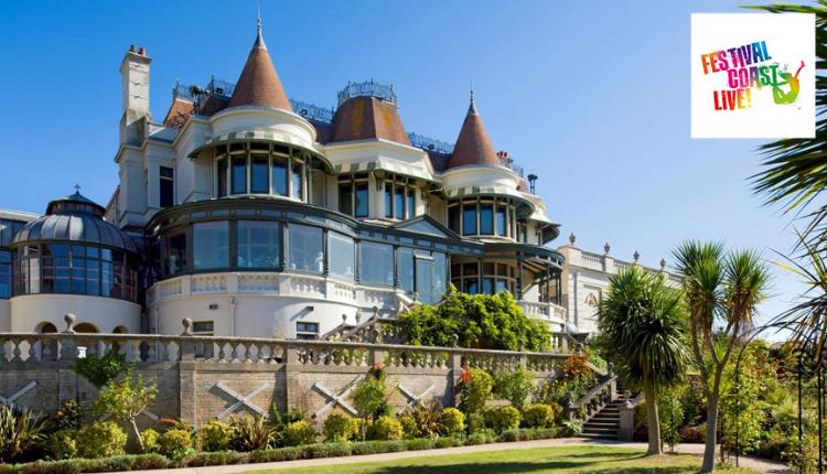 The Russell-Cotes Victorian Villa with blue sky in the background and green lawn in the foreground