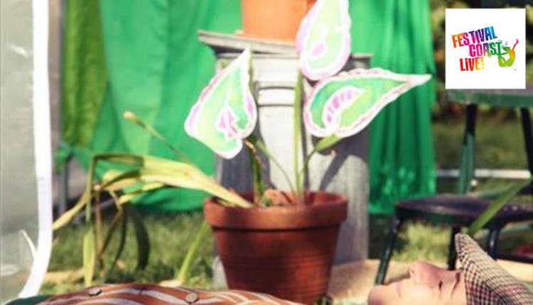 man lying on his back beside a plant in a flowerpot