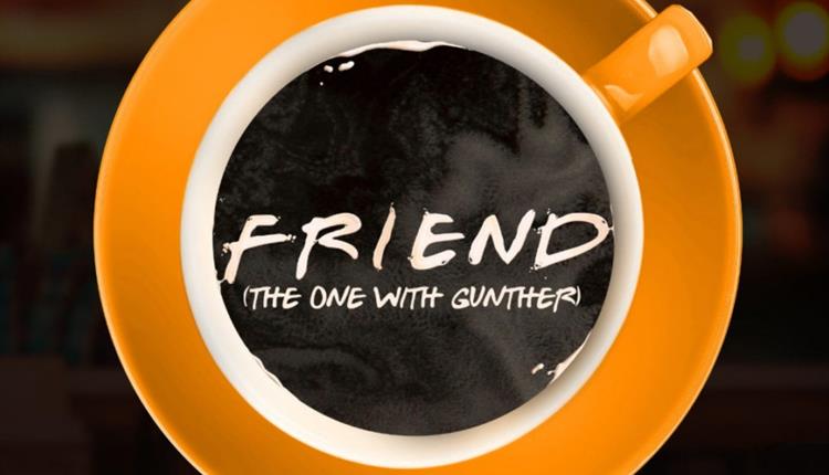 A white coffee cup on an orange saucer shot from overhead with the show title 'Friend (The One With Gunther)' in the middle of the coffee