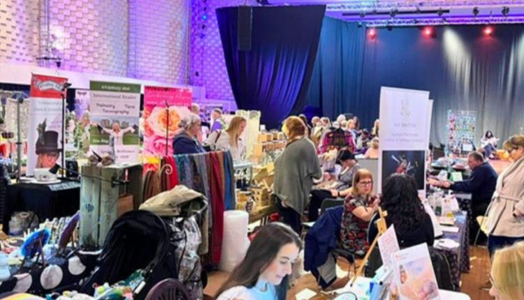 Image of previous festival with multiple booths set up and people milling about