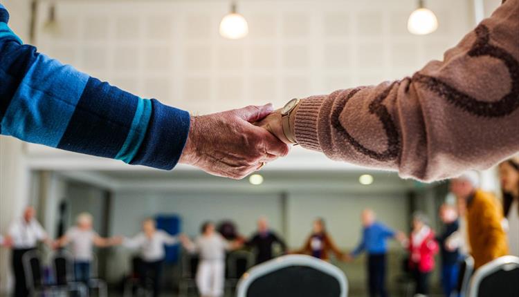 two people holding hands, one being old