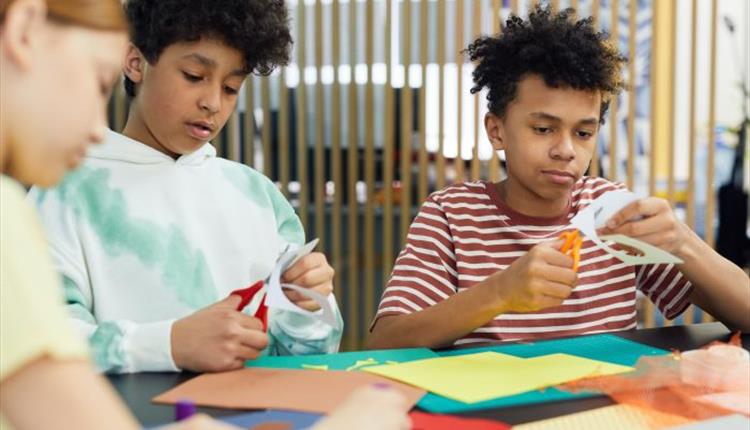 three children doing arts and crafts at a table