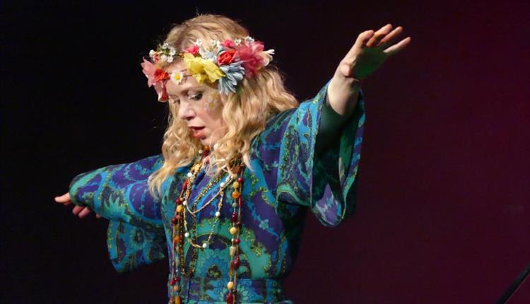 lady with flowers in her hair raising her arms at The Summer of Love concert