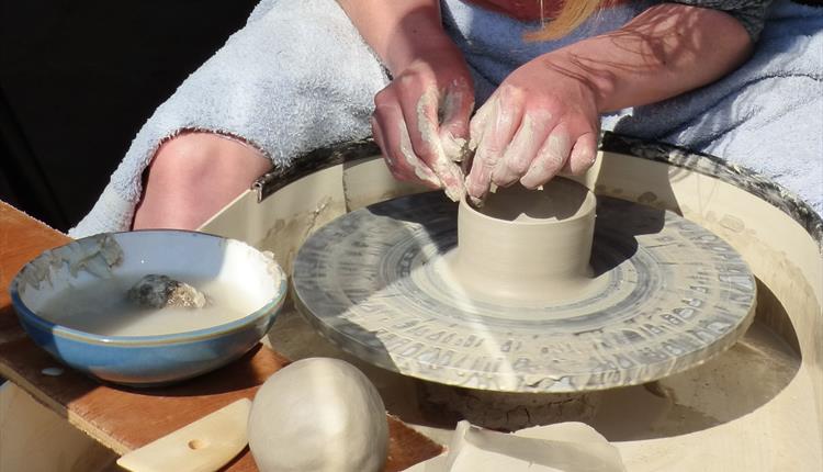 Person working on a piece of clay