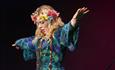 lady with flowers in her hair raising her arms at The Summer of Love concert